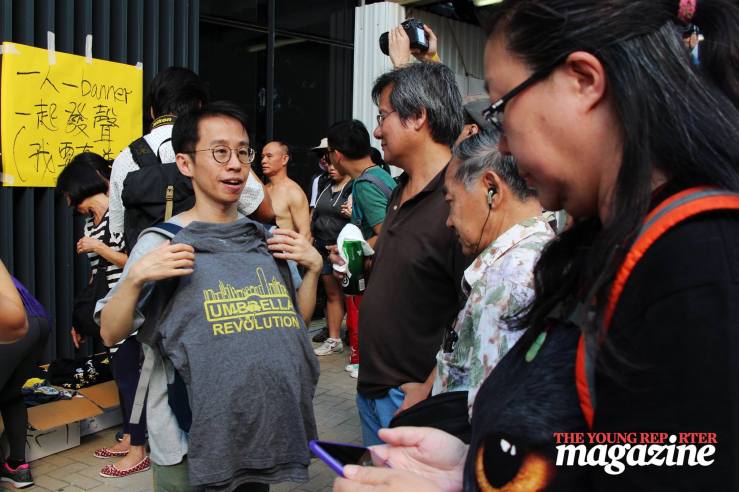 Man holds up a free t-shirt commemorating the Umbrella Movement | Legislative Council Complex | September 28, 2015 | Tanya McGovern